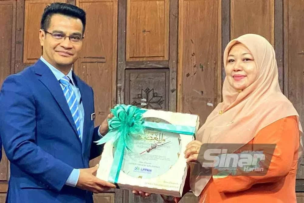 Haslinda (kanan) menyampaikan cenderamata kepada Prof Dr Arham pada Sambutan Hari Penduduk Sedunia Peringkat Negeri Kelantann 2025 yang diadakan di Dewan Keusahawanan UMK Kampus Kota, Pengkalan Chepa di Kota Bharu pada Selasa.