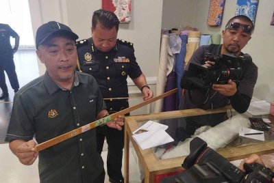 Mohd Sabri menunjukkan pembaris yang tidak ditentusahkan di sebuah kedai tekstil di ibu kota pada Selasa