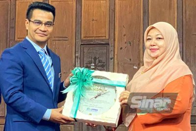 Haslinda (kanan) menyampaikan cenderamata kepada Prof Dr Arham pada Sambutan Hari Penduduk Sedunia Peringkat Negeri Kelantann 2025 yang diadakan di Dewan Keusahawanan UMK Kampus Kota, Pengkalan Chepa di Kota Bharu pada Selasa.
