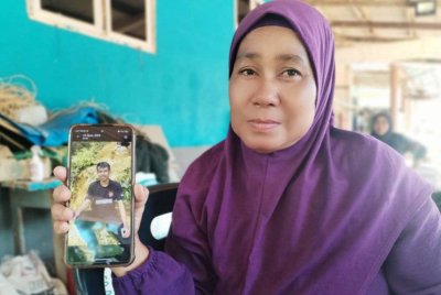 Mek Jarah menunjukkan gambar Allahyarham Muhamad Amirul Hakim.