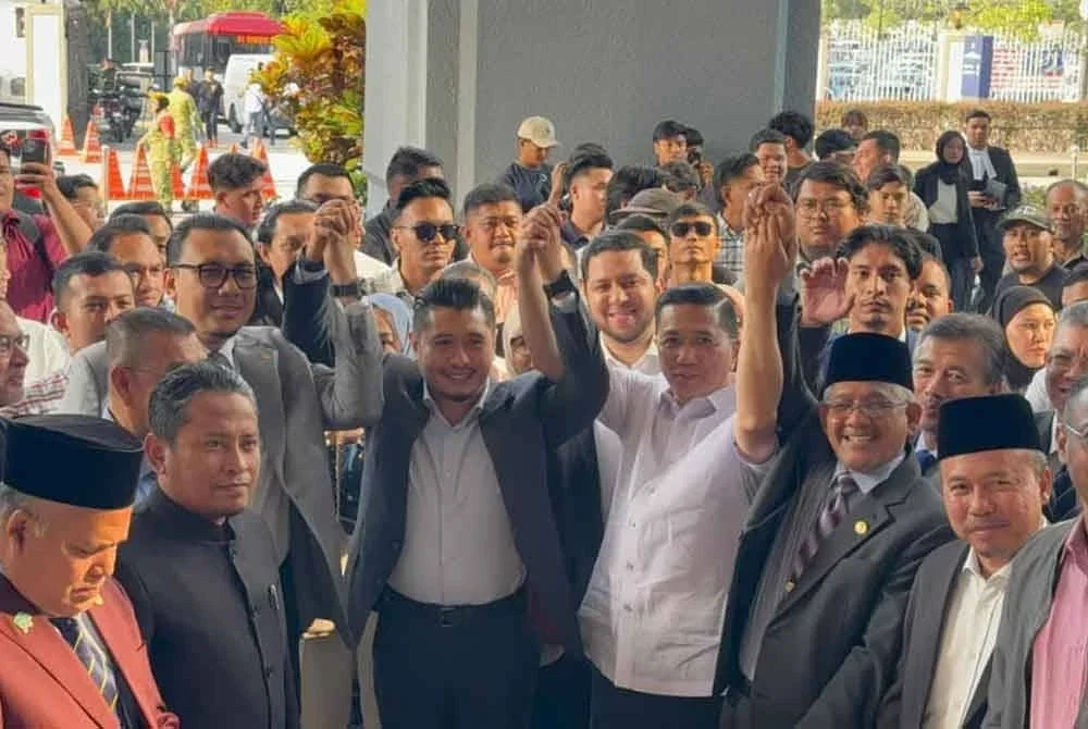 Hilman Idham (empat dari kiri) yang memakai kot berwarna hitam, mengangkat tangan bersama
Setiausaha Agung Bersatu, Datuk Seri Mohamed Azmin Ali dan penyokongnya ketika hadir ke Mahkamah Majistret Kuala Lumpur bagi menghadapi satu pertuduhan menimbulkan kegentaran awam, bulan lalu.