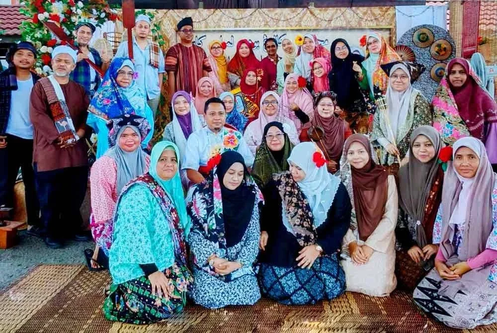 Roslah (duduk, tengah) bergambar kenangan bersama warga SK Lebu ketika majlis persaraannya pada Isnin.