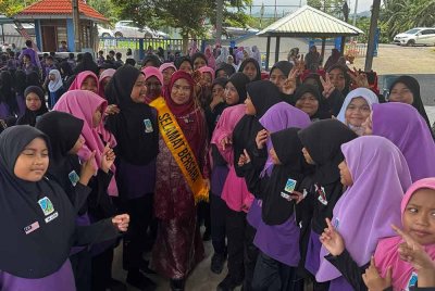 Roslah (tengah) bersama anak-anak muridnya di SK Lebu yang meraikan persaraannya pada Isnin.