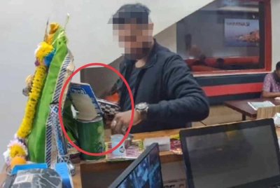 Tangkap layar rakaman CCTV seorang lelaki yang dipercayai menampal kod QR milik sendiri di sebuah restoran. Foto tular media sosial