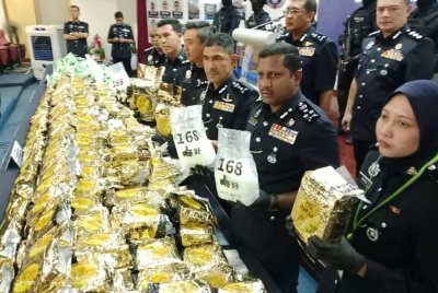 Hussein (dua, kanan) menunjukkan antara dadah yang dirampas dalam siri serbuan yang dijalankan pada Isnin.