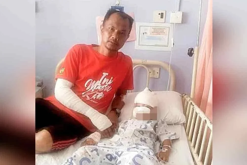 Mohd Suhaimi bersama anaknya, Mohammad Ayaaz Sabeer yang cedera apabila motosikal ditunggang berlanggar dengan anjing yang meluru dalam kejadian pada Rabu.