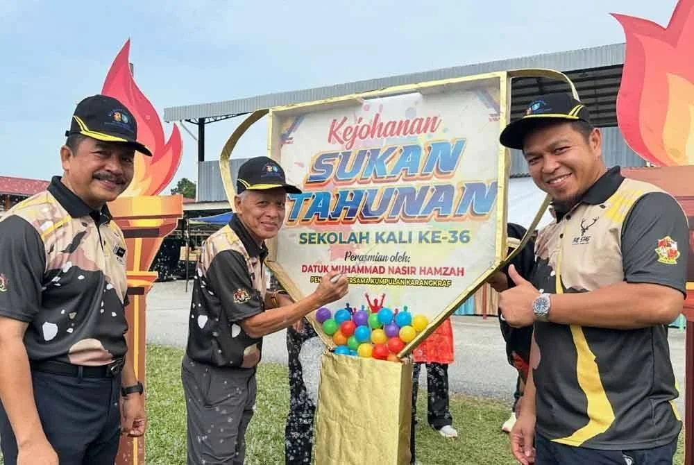 Muhammad Nasir (dua dari kiri) menandatangani plak hari kejohanan sukan diiringi Mohd Nawawi (kiri) dan Dr Mohd Nazrul pada Majlis Perasmian Sukan Tahunan ke-36 Sekolah Kebangsaan (SK) Seri Ketereh, di Kota Bharu pada Khamis.