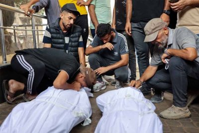 Penduduk Palestin meratapi jenazah mangsa yang terbunuh ketika mencari bantuan berhampiran Zikim, utara Genting Gaza. - AFP