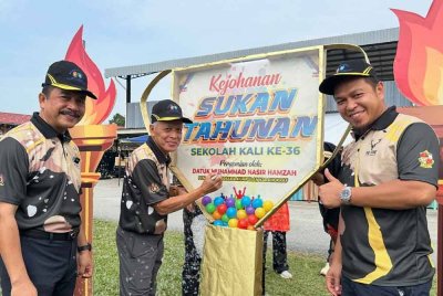 Muhammad Nasir (dua dari kiri) menandatangani plak hari kejohanan sukan diiringi Mohd Nawawi (kiri) dan Dr Mohd Nazrul pada Majlis Perasmian Sukan Tahunan ke-36 Sekolah Kebangsaan (SK) Seri Ketereh, di Kota Bharu pada Khamis.