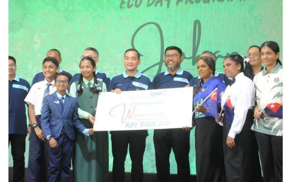 Onn Hafiz (tengah) menyampaikan hadiah kepada johan pertandingan Eco-Day, murid-murid SJK Tamil Taman Ungku Tun Aminah.