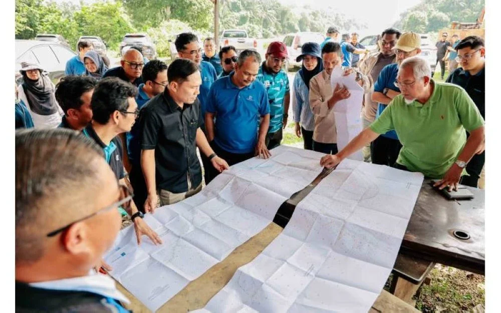 Radzuan meneliti pelan bersama pasukan teknikal semasa lawatan tapak projek pembinaan LRA Sungai Karangan Fasa 1.