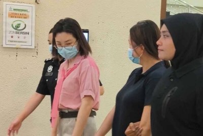 Shin Yin (kiri) dan adiknya, Shin Hua (dua dari kanan) mengaku tidak bersalah di dua Mahkamah Sesyen Kuala Lumpur pada Jumaat atas pertuduhan pecah amanah.