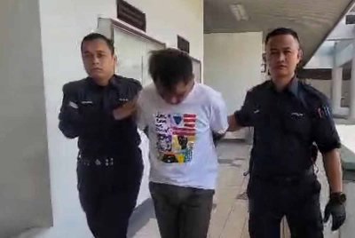 Mohd Suhaimi (tengah) ketika dibawa keluar dari Mahkamah Majistret Melaka pada Jumaat.