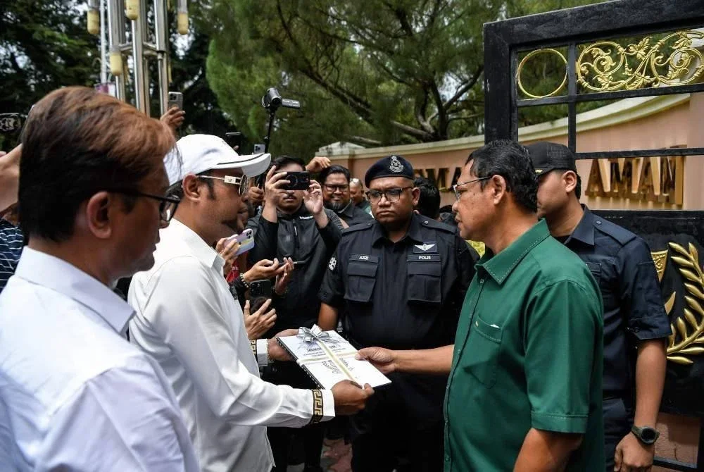 Sulaiman (dua dari kiri) menyerahkan memorandum ‘10 Kegagalan Isu Utama Rakyat Kedah’ kepada Mohd Zohir (kanan) untuk diserahkan kepada Muhammad Sanusi di hadapan Wisma Darul Aman, Alor Setar pada Ahad.