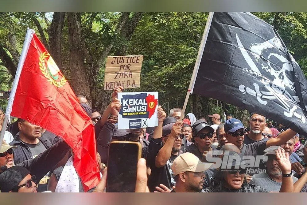 Peserta turut membawa sepanduk bertulis 'Justice for Adik Zara' dan bendera Malaysia sebagai tanda solidariti dan semangat patriotik menjelang sambutan Hari Kebangsaan.