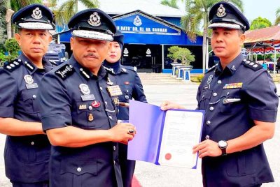 Mohd Yusoff (kiri) menyerahkan surat penghargaan kepada salah seorang pegawai pada Perhimpunan Bulanan di IPK Kelantan pada Ahad.