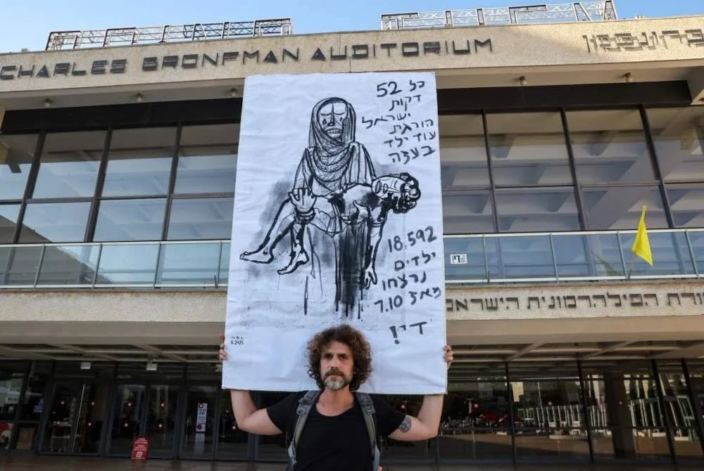 Seorang penunjuk perasaan membawa lukisan menunjukkan wanita Palestin memangku mayat kanak-kanak setelah golongan itu paling terkesan perang ganas tersebut. Foto AFP
