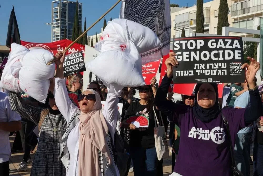 Peserta protes turut membawa bantal berwarna putih dengan 'tompokan darah' sebagai simbol kanak-kanak Gaza yang terkorban akibat kezaliman rejim Zionis. Foto AFP