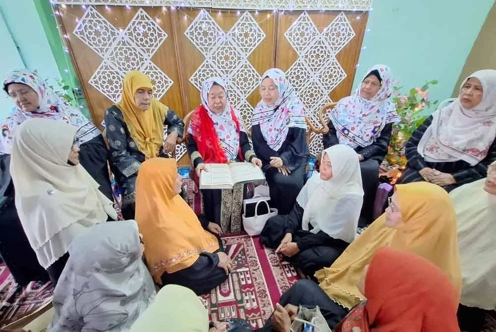 Normah (duduk, empat dari kanan) berkongsi manfaat membaca al-Quran ketika hadir ke Majlis Perasmian Rumah Ngaji Al-Syukriah Felcra Seberang Perak pada Ahad.