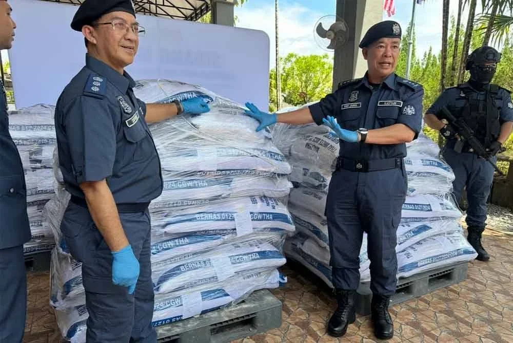 Wan Jamal Abdul Salam (tengah) menunjukkan beras yang dirampas pada sidang akhbar di Pejabat Cawangan Penguatkuasaan JKDM Kelantan, Rantau Panjang pada Isnin.