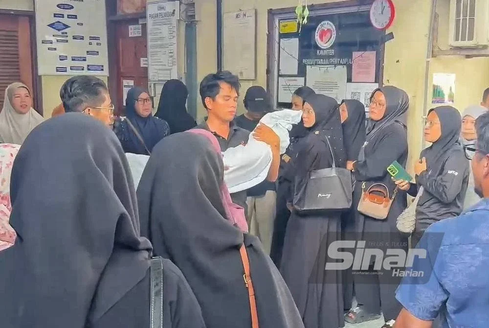 Azizi mendukung jenazah arwah anaknya keluar dari Unit Forensik Tengku Ampuan Afzan (HTAA) bagi menjalankan upacara pengebumian. Foto Sinar Harian
