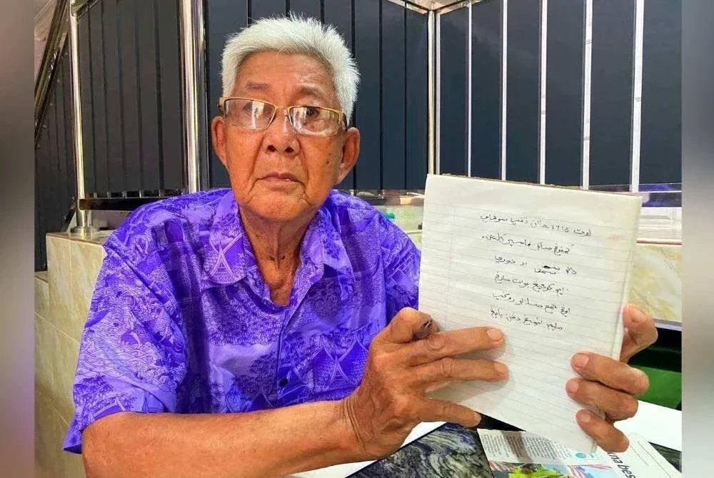 Mendiang Ching Lyu menunjukkan tulisannya dalam harafiah jawi.