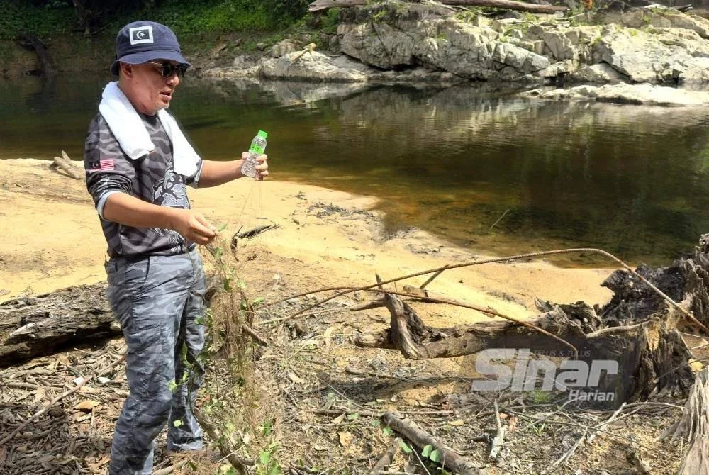 Razali menunjukkan pukat yang ditemui tersangkut di laluan masuk lubuk Santuari Kelah ketika tinjauan di lokasi itu pada Isnin.