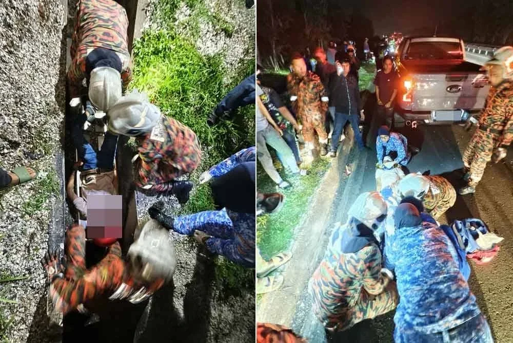Anggota bomba sedang membawa naik mangsa dari longkang.