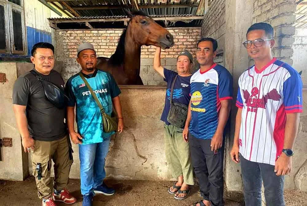 Dari kiri: Wan Mohd Ridhuan, Zainuddin dan Zukri bersama Mohd Rosdi (kanan) bersama seekor kuda di sebuah kandang.