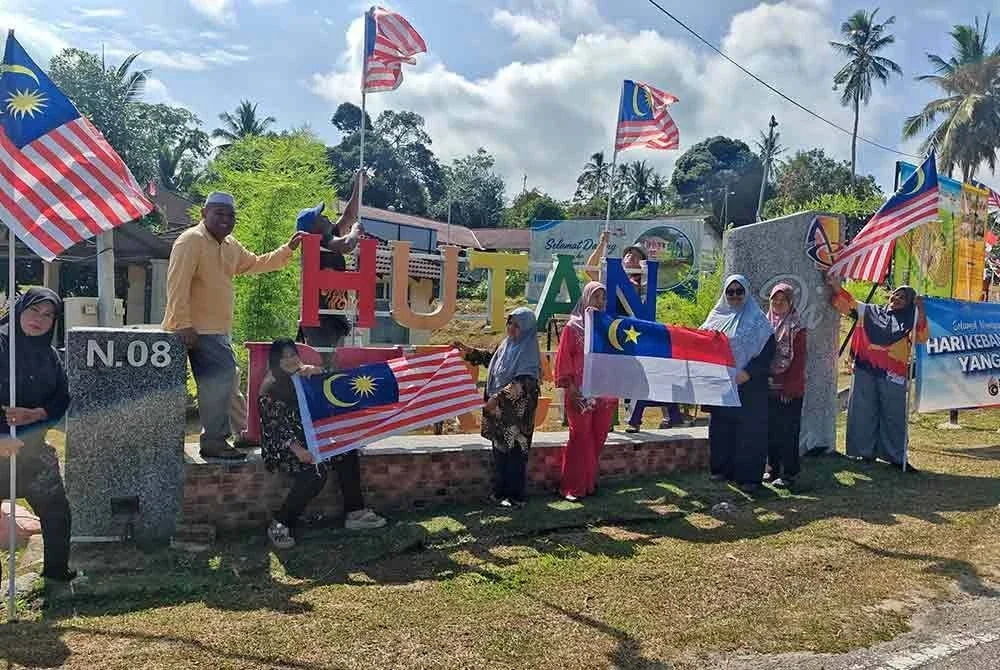 Penduduk Felda Hutan Percha, Machap, Alor Gajah mengibarkan Jalur Gemilang dan bendera negeri Melaka.