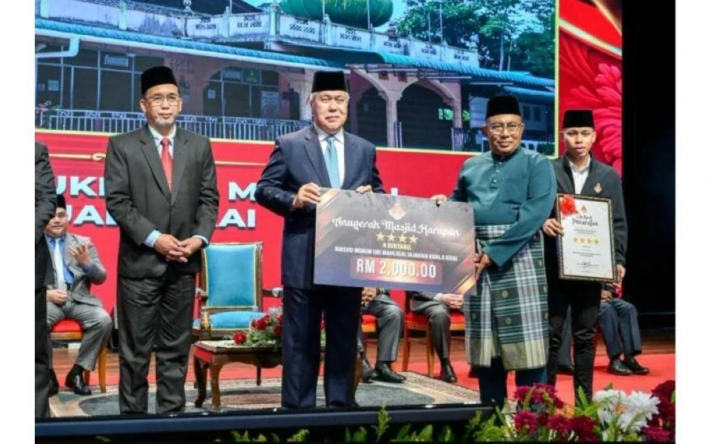 Tengku Mohamad Rizam (dua dari kiri) menyampaikan Anugerah Masjid Harapan kepada Masjid Mukim Sri Mahligai Kuala Krai yang diterima oleh Imam Tua masjid itu, Muhamad Razali Makhtar (dua dari kanan).