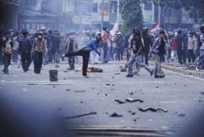 Penunjuk perasaan yang bertindak agresif ketika cuba mara ke bangunan Parlimen di Jakarta pada Isnin. Foto Agensi