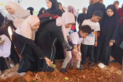 Ahli keluarga menyiram pusara Allahyarham Datuk Che Zakaria Mohd Salleh yang selamat disemadikan di Tanah Perkuburan Islam Mumainah, Pasir Gudang.