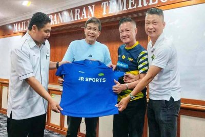 Rizal (kiri) bersama baju yang ditandatangani Kok Keong (dua dari kanan) dan Bobby (dua dari kiri).