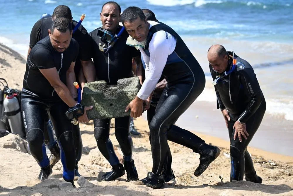 Penyelam mengangkat artifak ke darat.