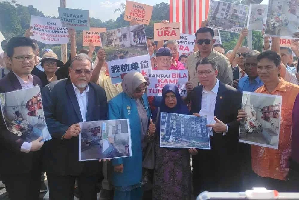Kor Ming (dua dari kanan) dan penduduk menunjukkan keadaan flat yang telah usang semasa menerima memorandum menyokong RUU PSB di hadapan bangunan Parlimen di Kuala Lumpur pada Rabu.