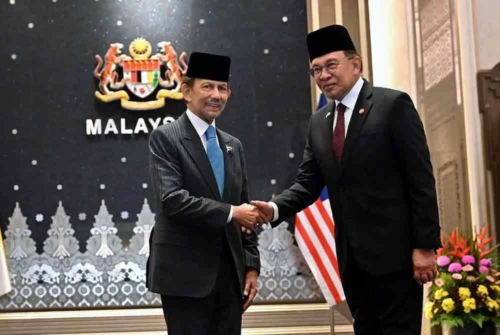 Sultan Hassanal Bolkiah (kiri) bersalaman dengan Anwar (kanan) sempena Rundingan Tahunan Pemimpin Malaysia–Brunei (ALC) ke-26 di Kompleks Seri Perdana. Foto Bernama