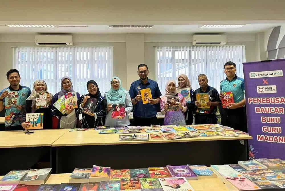 Mohd Khir (dua dari kanan) bergambar bersama Pengetua, Siti Dewi Marsitah Ismail (lima dari kiri) dan guru-guru yang menebus baucar buku pada Rabu.