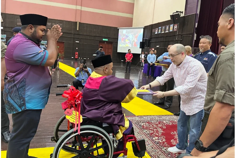 Tengku Muhammad Fakhry (kanan) menyampaikan sijil tamat latihan kepada OKU.
FOTO SINAR HARIAN - ADILA SHARINNI WAHID