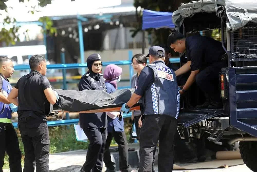 Polis mengangkat mayat mangsa yang disyaki dibunuh dengan dilanggar sebuah lori bonded awal pagi Rabu. Foto pembaca