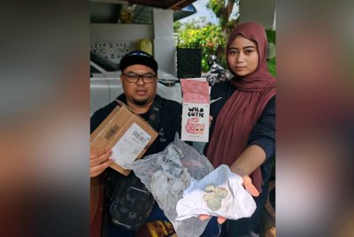 Putriquxiara dan bapanya, Md Sarrif menunjukkan bungkusan mengandungi batu yang diterimanya selepas membuat pembelian rantai kunci di TikTok.