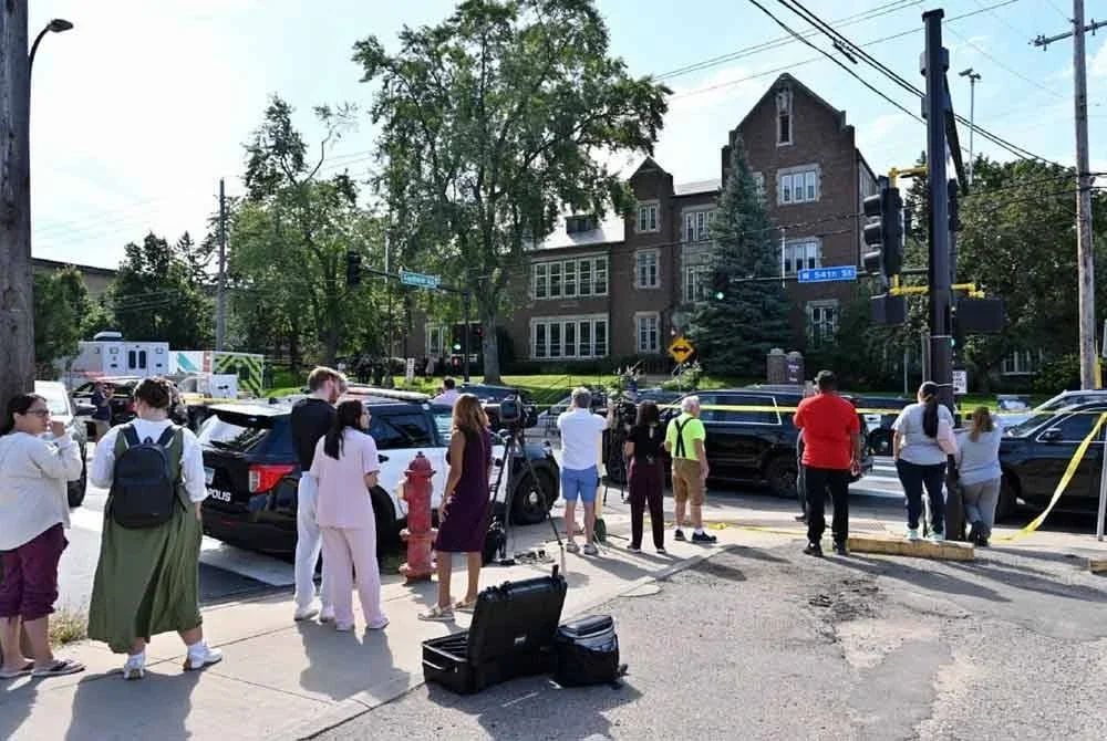 Orang awam dan media kelihatan berhampiran lokasi kejadian tembakan di Sekolah Katolik Annunciation di Minneapolis, Minnesota, pada Rabu.