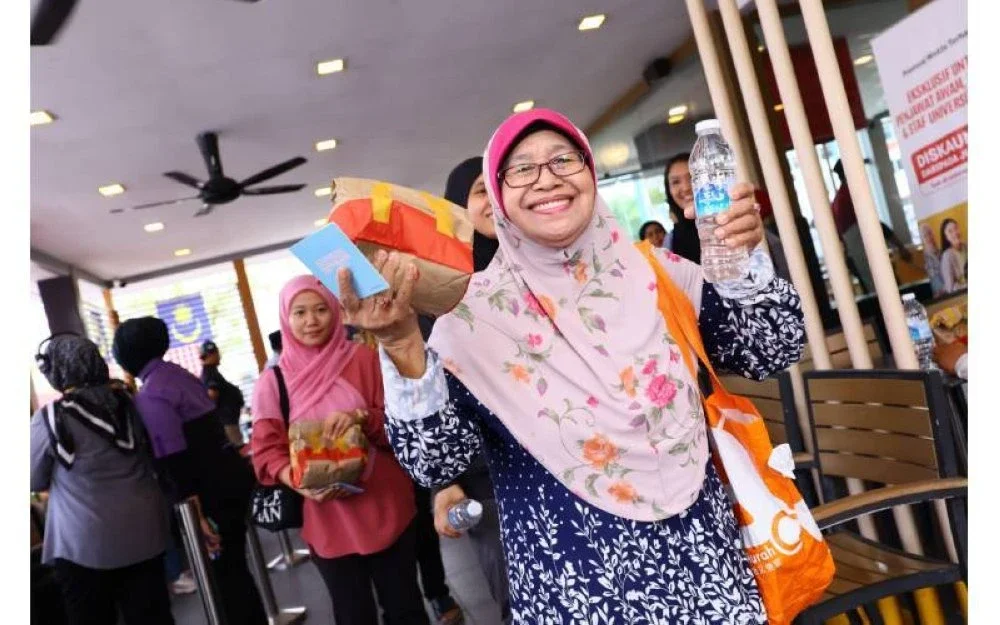 Seorang pelanggan gembira menerima pek hidangan percuma.