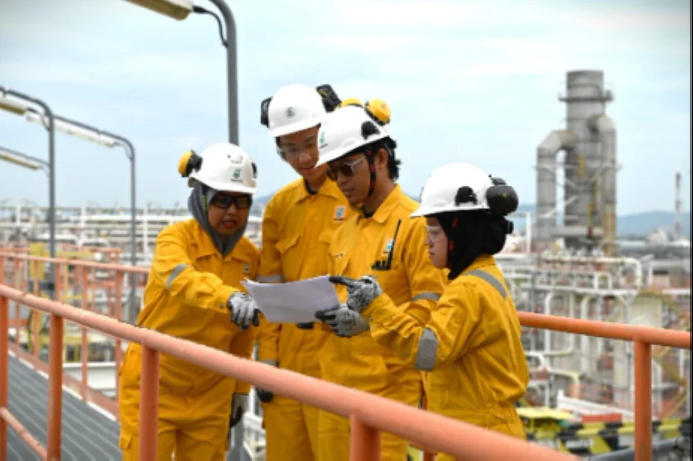 Norhusna (pertama dari kiri) berbincang mengenai perancangan operasi bersama rakan sekerja di Terminal Gas Terengganu.