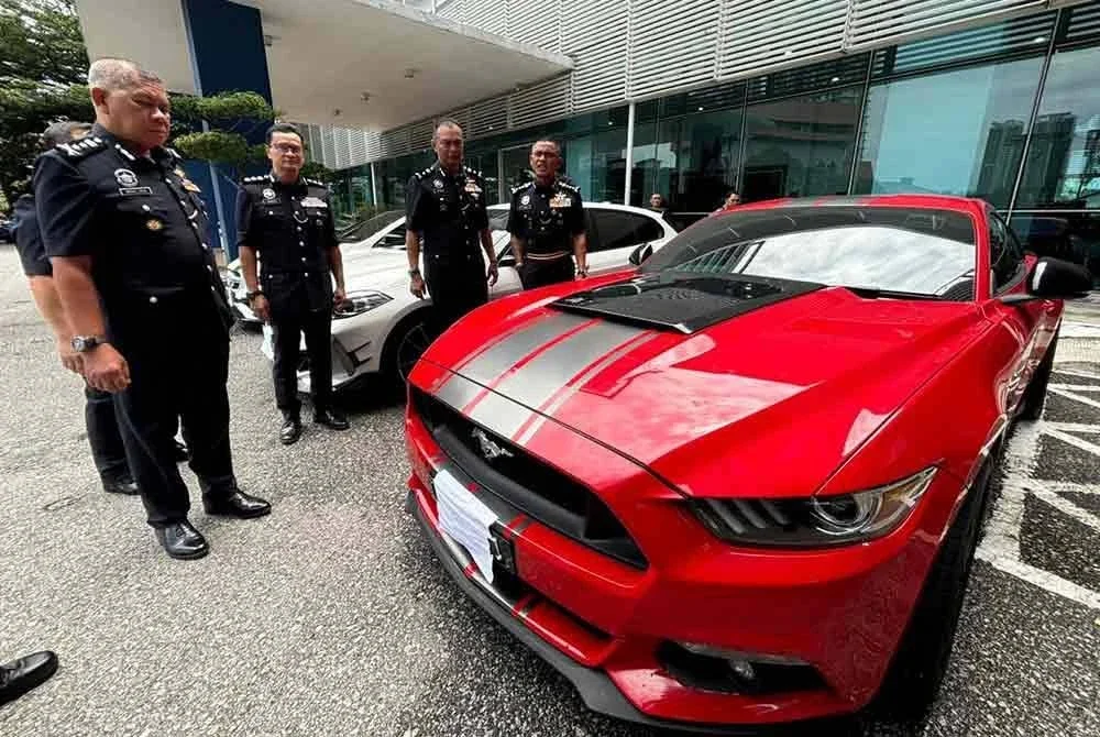 Fadil (kanan) melihat antara kenderaan mewah yang dirampas melibatkan ahli sindiket pengedaran dadah 22 Ogos lalu.