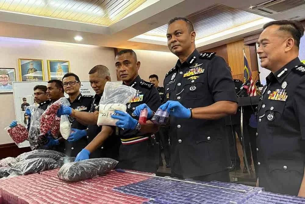 Fadil (tiga dari kanan) menunjukkan dadah jenis MDMA yang dirampas dalam serbuan di ibu negara 22 Ogos lalu.