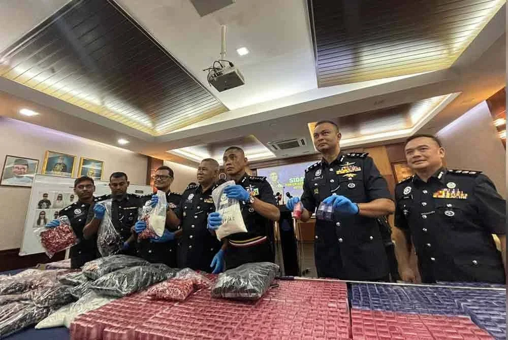 Fadil (tiga dari kanan) menunjukkan dadah jenis MDMA yang dirampas dalam serbuan di ibu negara 22 Ogos lalu.