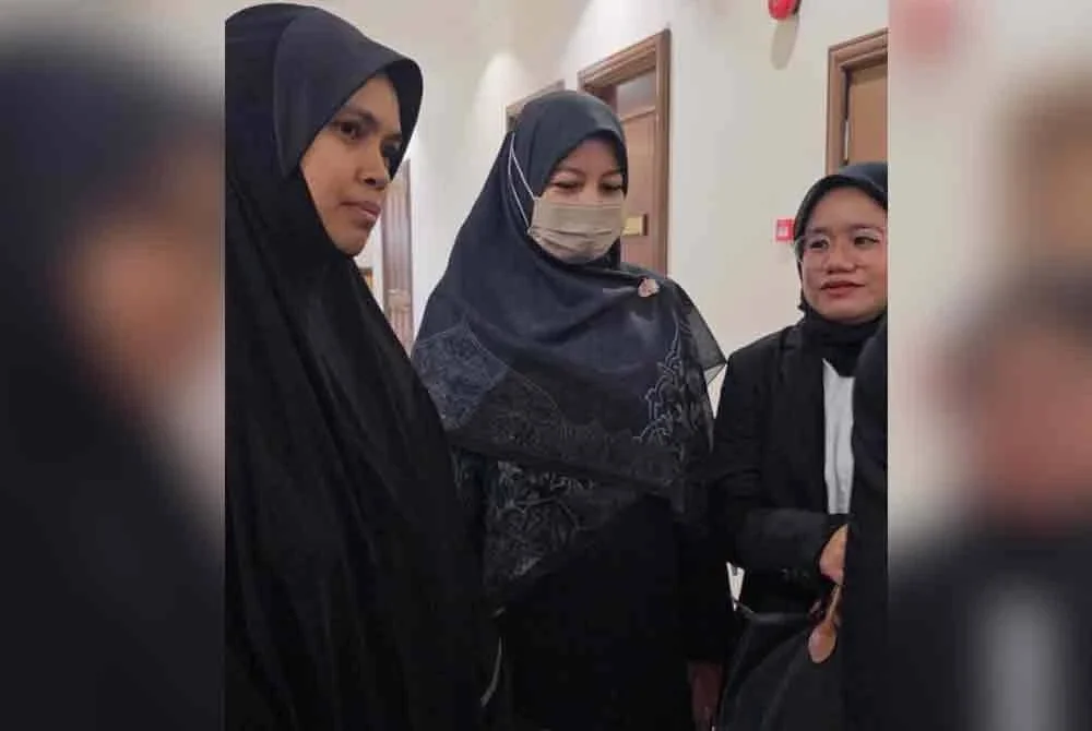 Noraidah (tengah) ketika hadir pada prosiding pendengaran permohonan pasukan peguam untuk dideklarasi sebagai pihak berkepentingan dalam inkues kematian anaknya pada Khamis.