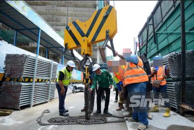 Mohd Hatta (tengah) memeriksa peralatan kren yang digunakan bagi memastikannya mengikut prosedur yang ditetapkan. Foto Sinar Harian - MOHD HALIM ABDUL WAHID