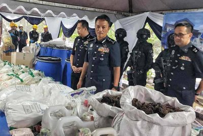 Dzulkhairi (tengah) melihat sebahagian dadah berbahaya yang akan dilupuskan.